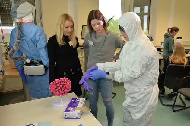 Dr. Ramona Vestweber und Dr. Berit Roshani erklären, welche Schutzkleidung in den unterschiedlichen Laboren notwendig ist. Foto: Katharina Diederich